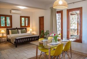 a bedroom with a bed and a table and chairs at PYRGOS RALLI ESTATE Guesthouse in Egina
