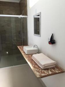a bathroom with a sink and a shower at Pousada das Palmeiras in Salinópolis