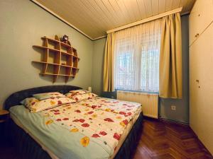 sypialnia z łóżkiem i oknem w obiekcie Rita Apartman Balatonszéplak w Siófoku