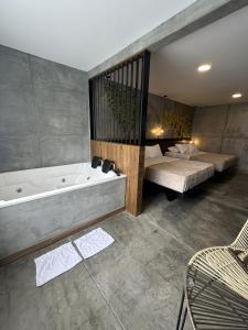 ein Bad mit einer Badewanne, einem Bett und einer Badewanne in der Unterkunft Eco Hotel La Colina Mirador in Quimbaya