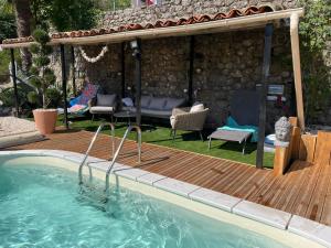 a swimming pool on a wooden deck with a gazebo at La Storya in Meyras