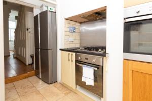 a kitchen with a stove and a refrigerator at Suite 3 - Trendy Private Room near City Centre in Manchester
