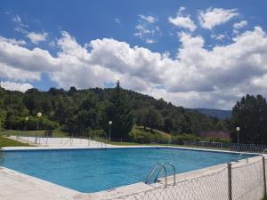 ein großes Schwimmbecken mit einem Zaun drumherum in der Unterkunft Matandrino in Prádena