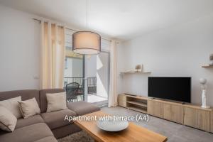 a living room with a couch and a flat screen tv at La Mer Adriatique in Makarska
