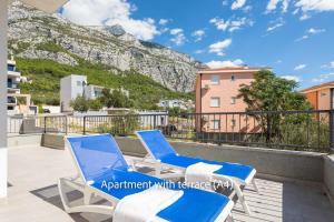 a pair of chairs on a balcony with a mountain at La Mer Adriatique in Makarska