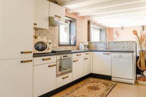 a kitchen with white cabinets and a stove top oven at Cynnewille in Ee