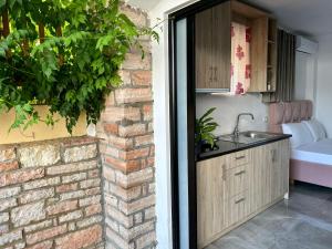 una cucina con lavandino e muro di mattoni di Vila Laura a Ksamil