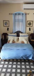 a bedroom with a blue bed with a blue curtain at La Provençale in Jerusalem