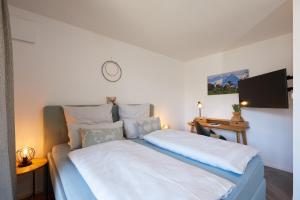 a bedroom with a bed and a tv on the wall at 3KORNHAUS - Das neue Alpendomizil in Garmisch-Partenkirchen