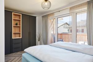 a bedroom with a large bed and a large window at 3KORNHAUS - Das neue Alpendomizil in Garmisch-Partenkirchen +17 photos