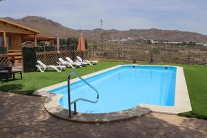una piscina en un patio con sillas y una casa en Cortijo Pinar 2, en Níjar