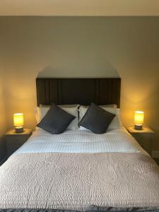 una camera da letto con un letto grande con due lampade di Abhaile Air a Killarney