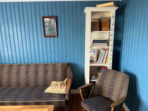 a living room with a couch and a chair at Berunes HI Hostel in Berunes