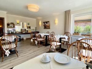 a restaurant with tables and chairs and a kitchen at Haus Kap Horn in Juist