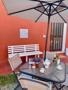 a table and chairs under an umbrella on a patio at Casetta Oasi Campo ai Peri in Casa Marchetti