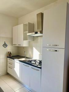 a kitchen with white cabinets and a white refrigerator at Casetta Oasi Campo ai Peri in Casa Marchetti