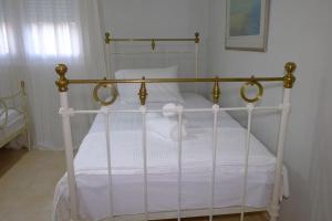 a white bed with a metal frame in a bedroom at Vintage Garden House in Doxato