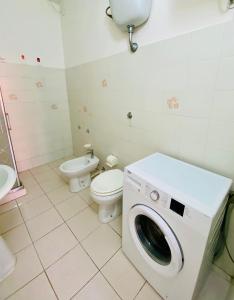 a bathroom with a washing machine and a toilet at Casetta Oasi Campo ai Peri in Casa Marchetti