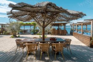 una mesa y sillas bajo una sombrilla en la playa en Villa Kirssis en Porticcio