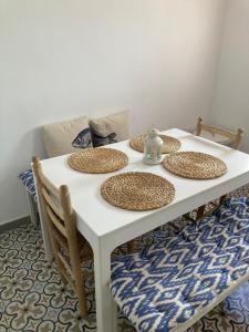 Una mesa blanca con cuatro sombreros de paja. en Moderna casa de pueblo en el casco viejo de Jávea, en Jávea
