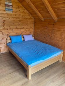 Bett in einer Holzhütte mit blauer Bettwäsche in der Unterkunft Begov kamp, Plav in Plav