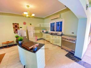 uma grande cozinha com um balcão e um frigorífico em Villa with a charming view, sea view, Marina em El Alamein