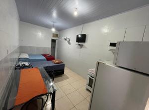 ブラジリアにあるHospedaria Cmc unidade 12のベッド2台、冷蔵庫が備わる小さな客室です。