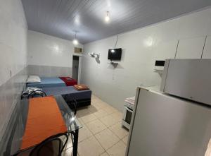 a small room with two beds and a refrigerator at Hospedaria Cmc unidade 12 in Brasilia