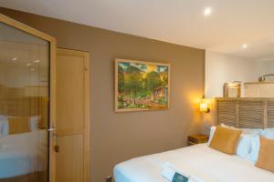 sypialnia z łóżkiem i obrazem na ścianie w obiekcie Villa Kirssis w mieście Porticcio