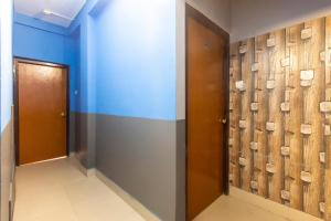 un corridoio con pareti blu e porte in legno di OYO ARV Hotels a Calcutta