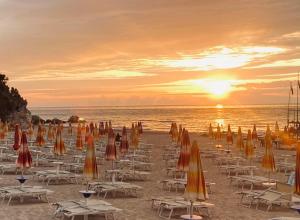 een strand met stoelen en parasols op het zand bij Appartamento Gargano in Carpino