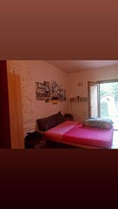 Schlafzimmer mit einem roten Bett und einem Fenster in der Unterkunft Casa di sotto in Giratola