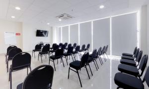 una sala de conferencias con sillas negras y una pared blanca en Sleep Inn Tijuana en Tijuana