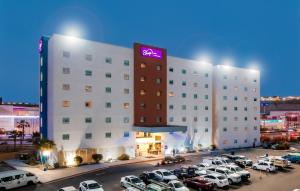 un gran hotel con coches estacionados en un estacionamiento en Sleep Inn Tijuana en Tijuana