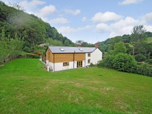 a house in a field with a grass yard at Exmoor Farmhouse in Tiverton