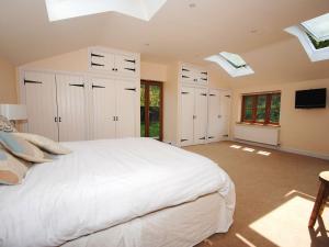 a bedroom with a large white bed and skylights at Exmoor Farmhouse in Tiverton