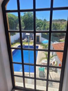 a view of a swimming pool through a window at Vicentina Rooms by Casas do Alentejo in Almograve