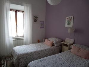 1 dormitorio con 2 camas y ventana en Soluna en Maresca