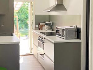 a kitchen with a microwave oven and a stove at 6 person holiday home in LAHOLM-By Traum in Laholm