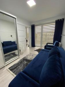 salon z niebieską kanapą i dużym lustrem w obiekcie Natura Resort "Bałtycki Sen" w Jastrzębiej Górze