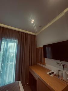 una camera d'albergo con scrivania e ampia finestra di Hotel Sole a Sarandë