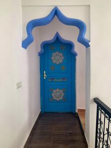 Una puerta azul en una habitación con escalera en Dar Saida Hora, en Chefchaouen