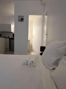 une chambre blanche avec un lit avec des serviettes dessus dans l'établissement Studio 8 - Bord de Loire, à Orléans