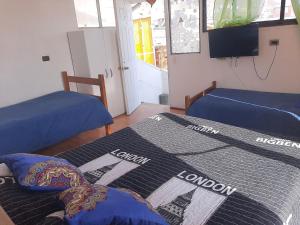 Habitación con 2 camas y TV. en Hostal Pampaloja en Antofagasta