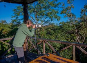 un hombre tomando una foto con una cámara en un puente en Treehouse Tulum H2Ojos en Tulum