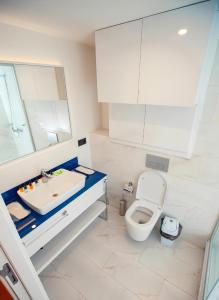 ein Badezimmer mit einem WC, einem Waschbecken und einem Spiegel in der Unterkunft Orbi City apartment with sea view in Batumi