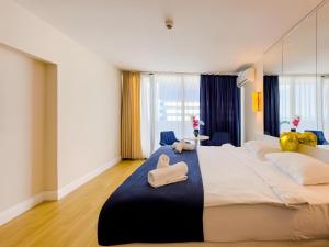 Orbi City apartment with sea view في باتومي: غرفة نوم بسرير كبير عليها منشفتين