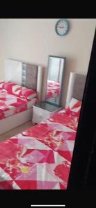 ein Schlafzimmer mit 2 Betten und einer Uhr an der Wand in der Unterkunft Aqua view Reasort in El Qasaba esh Sharqīya