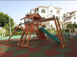 a playground with a slide in front of a house at Complex garden beach2 sidi rahal in Sidi Rahal