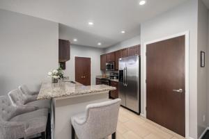 a kitchen with a counter and two bar chairs at HUGE New Apartment, Free Parking, Near Mayo! in Rochester +14 photos